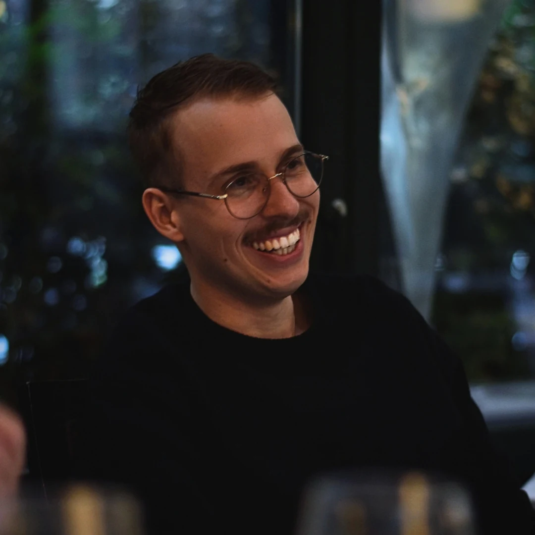 Christopher Krassnig laughing, in round glasses
